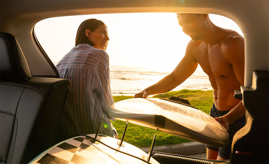 Loading an MG vehicle trunk with surf boards